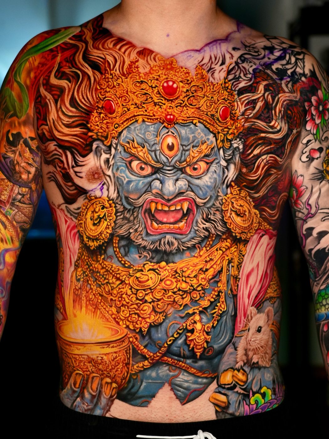 Detail of a wrathful deity back piece showing the face and gold ornament
